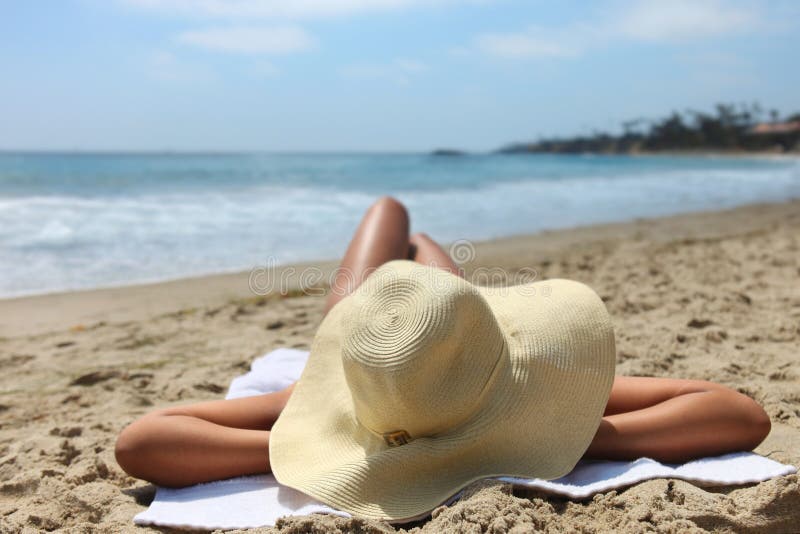 Mujer que presenta tomar el sol en la playa foto de archivo libre de regalías Mujer que presenta tomar el sol en la playa foto de archivo libre de regalías