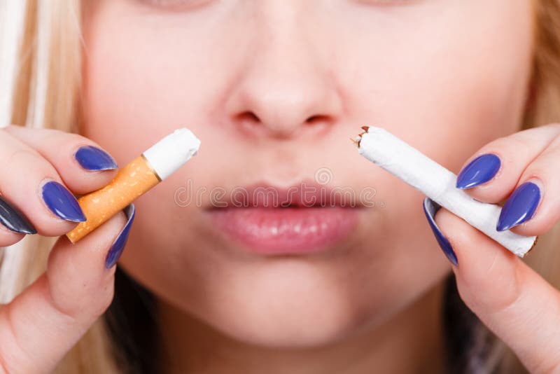 Mujer que rompe el cigarrillo, librándose del apego imagen de archivo Mujer que rompe el cigarrillo, librándose del apego imagen de archivo
