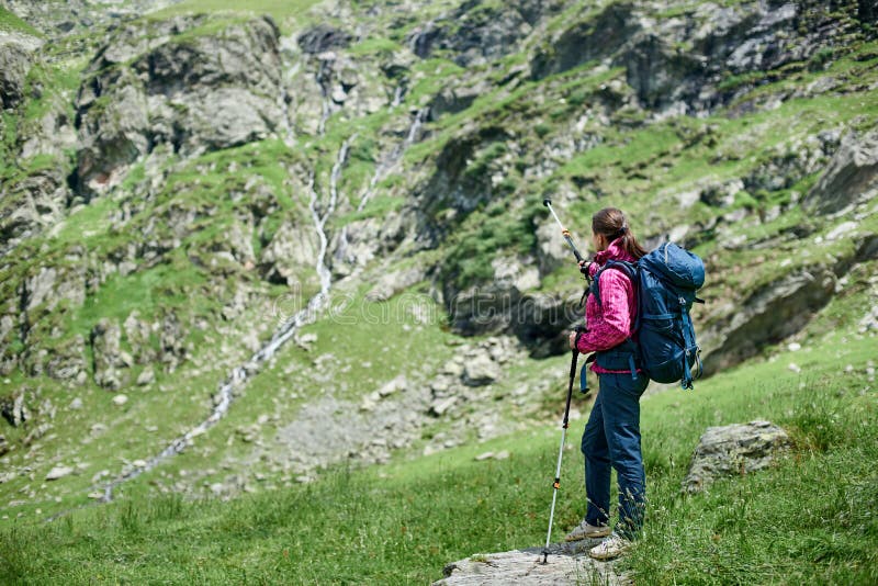 Mujer que se coloca en piedra en el pie de las montañas de Fagaras imagenes de archivo Mujer que se coloca en piedra en el pie de las montañas de Fagaras imagenes de archivo