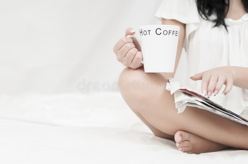Mujer que se relaja con café y un periódico foto de archivo libre de regalías Mujer que se relaja con café y un periódico foto de archivo libre de regalías