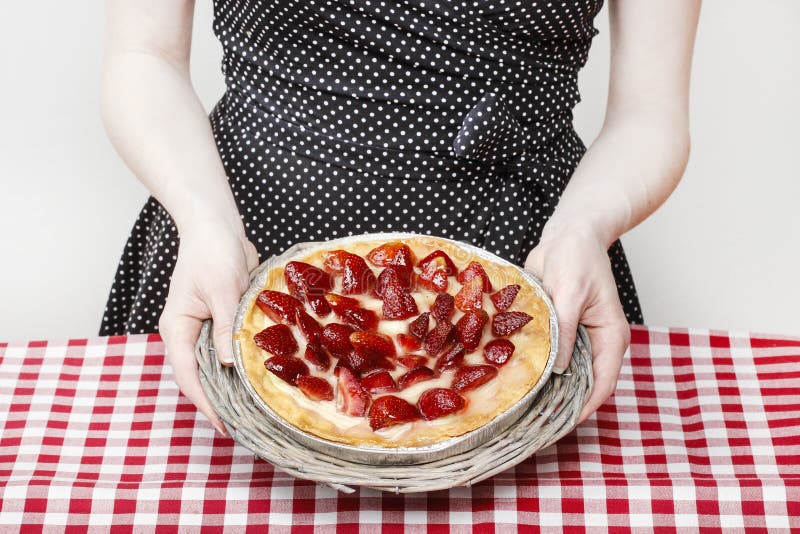 Mujer que se sostiene alrededor de la torta de la fresa imágenes de archivo libres de regalías Mujer que se sostiene alrededor de la torta de la fresa imágenes de archivo libres de regalías