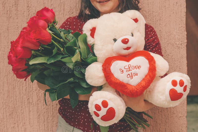 mujer que sostiene el juguete de las rosas rojas y del oso de peluche fotos de archivo libres de regalías mujer que sostiene el juguete de las rosas rojas y del oso de peluche fotos de archivo libres de regalías