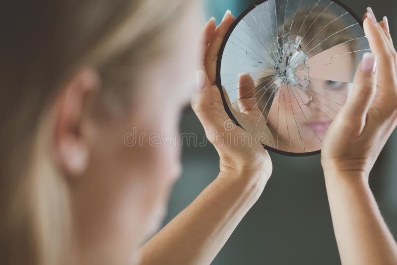 Woman with mental disorder holding small broken mirror. Woman with mental disorder holding small broken mirror