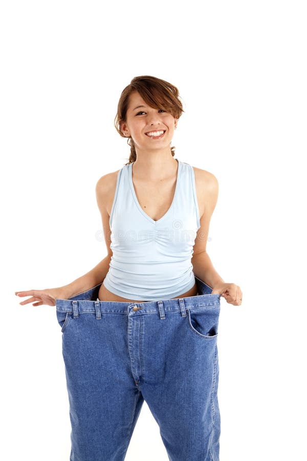 Mujer que sostiene hacia fuera los pantalones grandes fotografía de archivo Mujer que sostiene hacia fuera los pantalones grandes fotografía de archivo