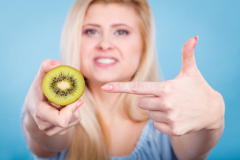 Mujer que sostiene la fruta de kiwi verde fotografía de archivo Mujer que sostiene la fruta de kiwi verde fotografía de archivo