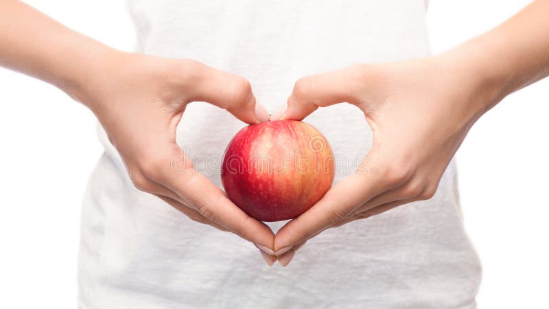 Mujer que sostiene la manzana en manos en forma de corazón imágenes de archivo libres de regalías Mujer que sostiene la manzana en manos en forma de corazón imágenes de archivo libres de regalías