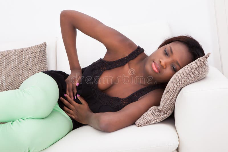 Mujer que sufre del dolor de estómago en casa
