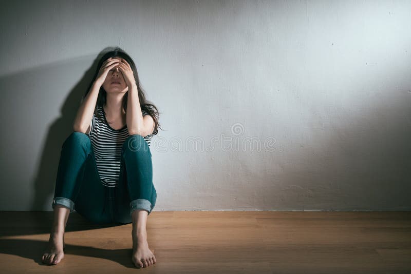 Elegant young woman having depression bipolar disorder trouble feeling confusion sitting on wooden floor resting in white background. Elegant young woman having depression bipolar disorder trouble feeling confusion sitting on wooden floor resting in white background.