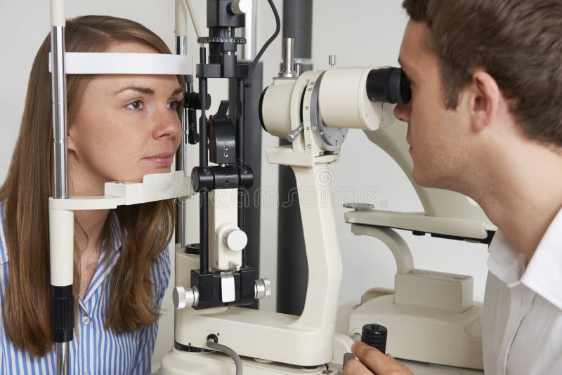 Mujer que tiene prueba de la vista en los ópticos