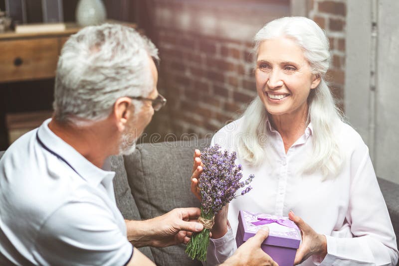 Mujer que toma el presente del hombre foto de archivo libre de regalías Mujer que toma el presente del hombre foto de archivo libre de regalías