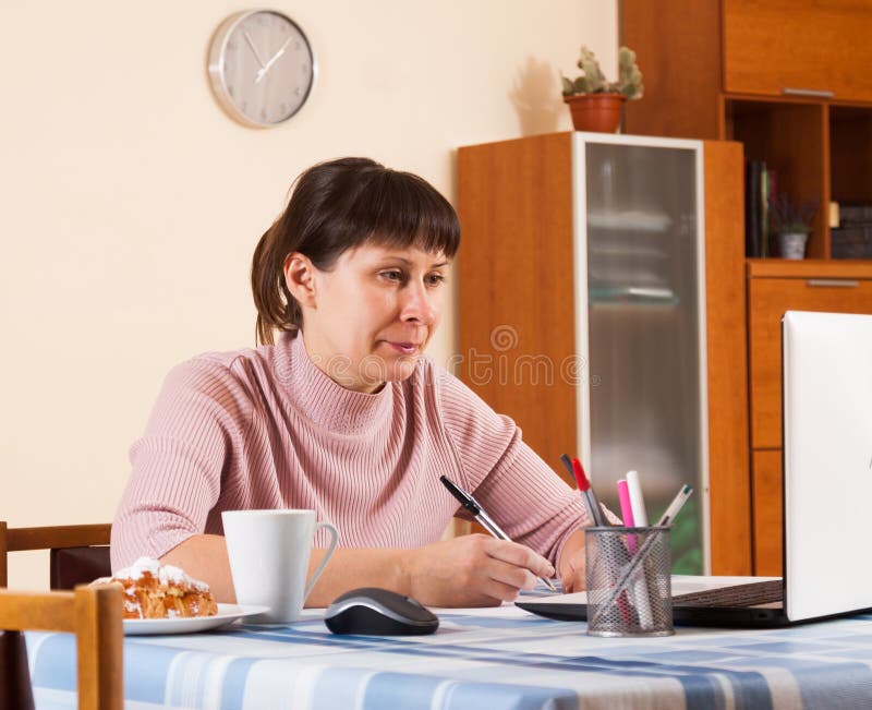 Mujer que trabaja en un ordenador portátil imagen de archivo Mujer que trabaja en un ordenador portátil imagen de archivo