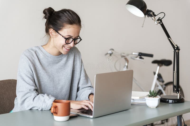 Mujer que usa el ordenador portátil del ordenador feliz fotografía de archivo libre de regalías Mujer que usa el ordenador portátil del ordenador feliz fotografía de archivo libre de regalías