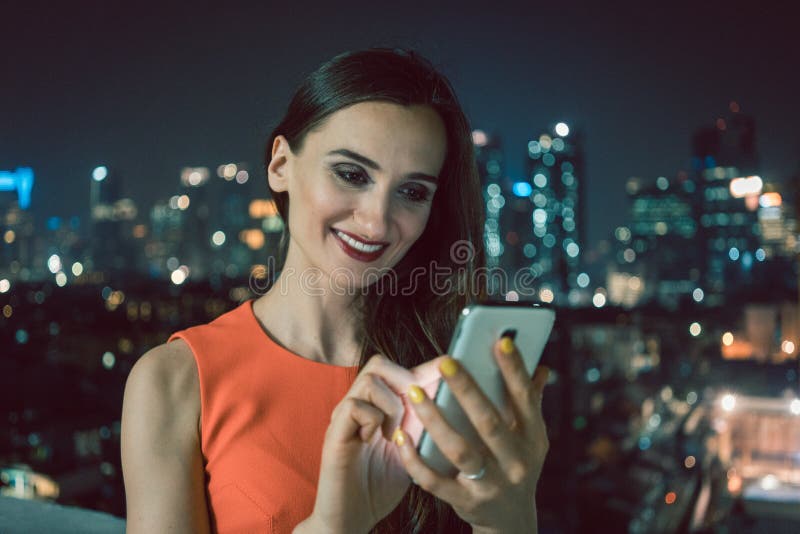 Mujer que usa el teléfono para los medios sociales en el ambiente urbano imágenes de archivo libres de regalías Mujer que usa el teléfono para los medios sociales en el ambiente urbano imágenes de archivo libres de regalías