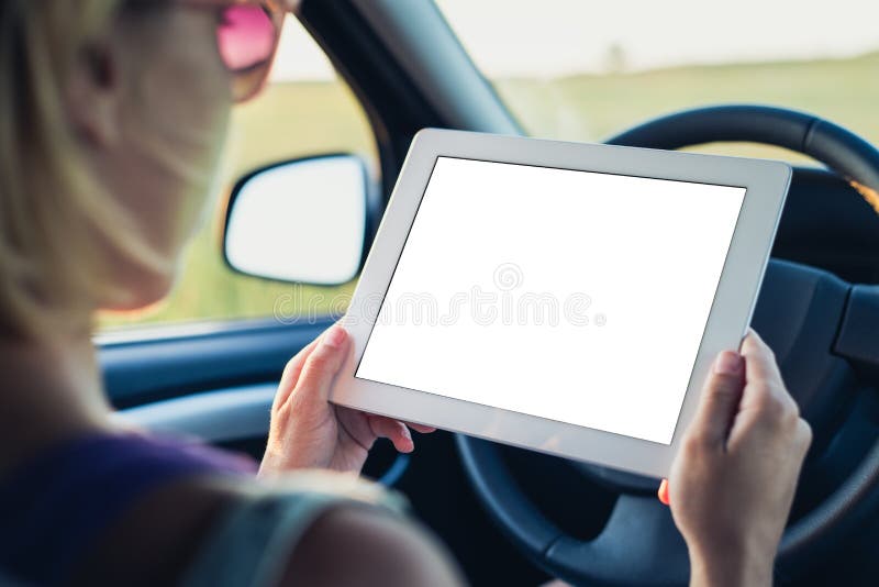 Mujer que usa la PC de la tablilla en el coche imagen de archivo Mujer que usa la PC de la tablilla en el coche imagen de archivo
