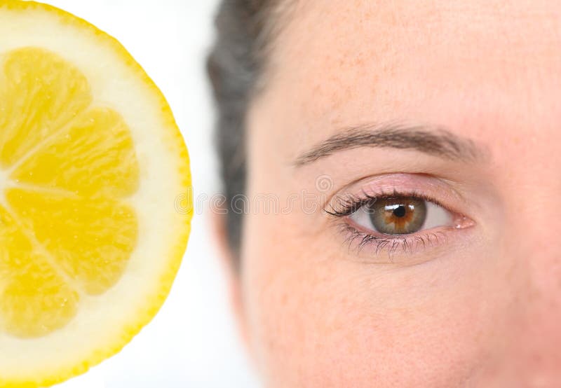 Close up of adult woman with fair skin using a natural lemon remedy to remove freckles. Close up of adult woman with fair skin using a natural lemon remedy to remove freckles