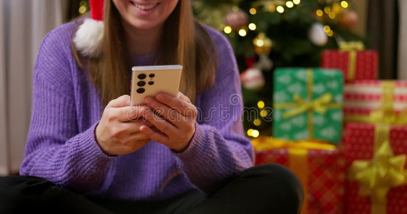 Mujer que usa smartphone cerca del árbol de navidad almacen de video