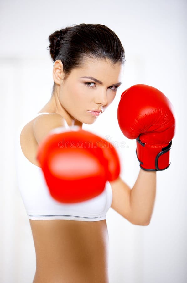 Mujer resuelta que lleva guantes de boxeo rojos foto de archivo Mujer resuelta que lleva guantes de boxeo rojos foto de archivo