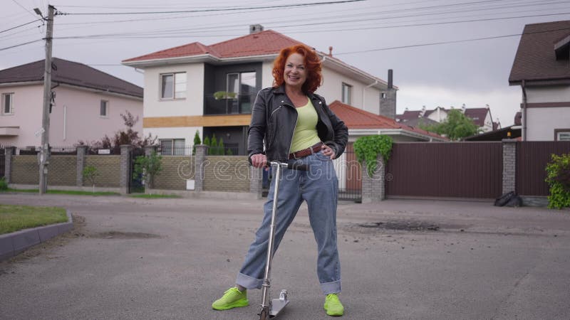 Mujer retro sonriente, de tiro amplio, de pie con patinador mirando a la cámara. retrato de caucásico de confianza almacen de video