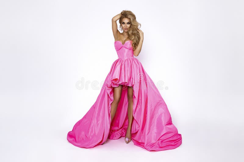 Mujer rubia chic con elegante vestido largo rosado con fondo blanco. moda nocturna de lujo. glamour y elegancia