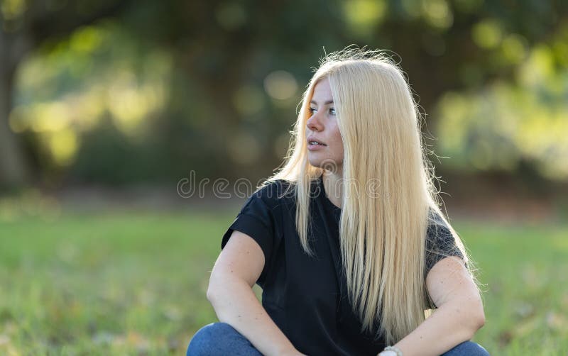 Mujer rubia con bragas sentada en el césped fotos de archivo libres de regalías