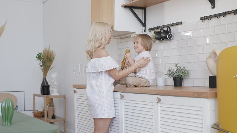 Mujer rubia con su hijo en la cocina. en un día libre madre e hijo están juntos.