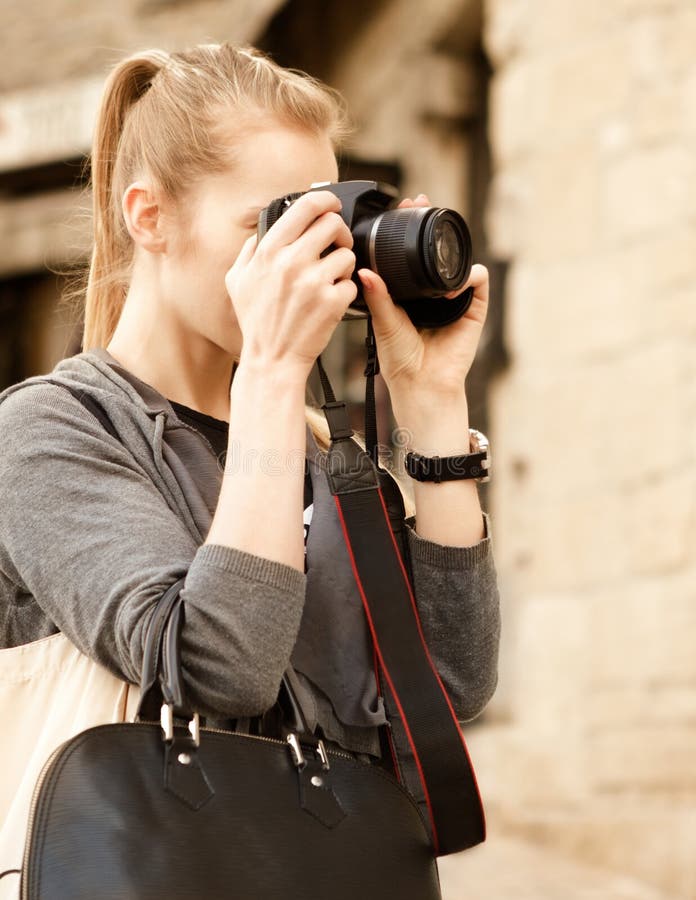 Mujer joven del viajero que sostiene la cámara fotografía de archivo Mujer joven del viajero que sostiene la cámara fotografía de archivo