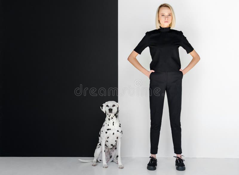 mujer rubia elegante hermosa en la ropa negra que se coloca cerca de la pared blanco y negro foto de archivo mujer rubia elegante hermosa en la ropa negra que se coloca cerca de la pared blanco y negro foto de archivo