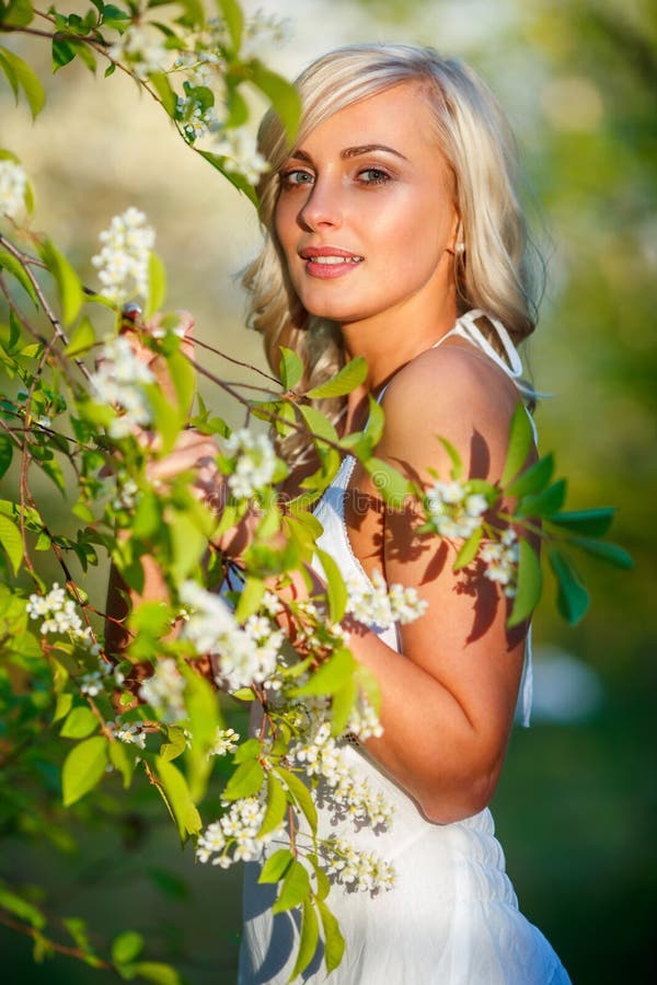 Mujer rubia en un jardín florecido imagen de archivo Mujer rubia en un jardín florecido imagen de archivo
