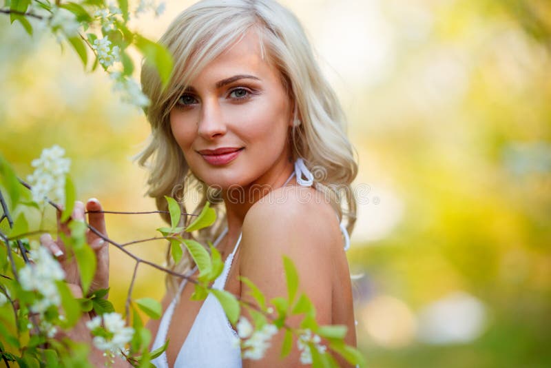 Mujer rubia en un jardín florecido fotografía de archivo libre de regalías Mujer rubia en un jardín florecido fotografía de archivo libre de regalías