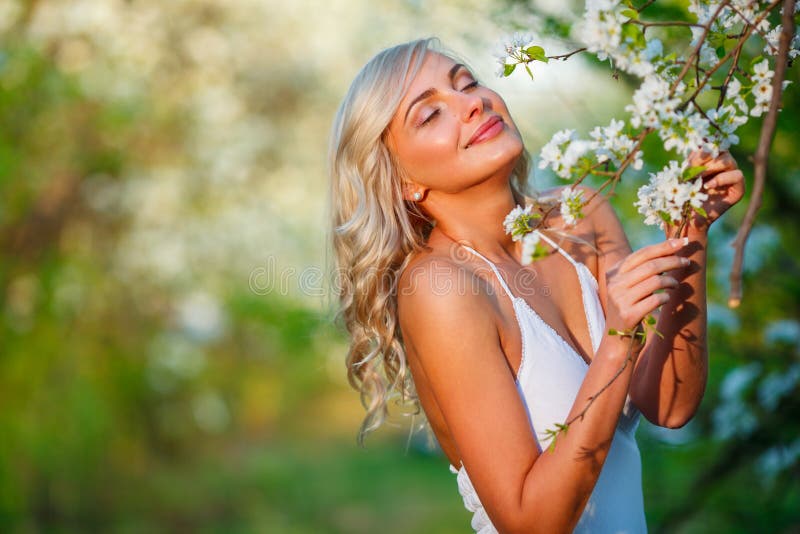 Mujer rubia en un jardín florecido imagenes de archivo Mujer rubia en un jardín florecido imagenes de archivo