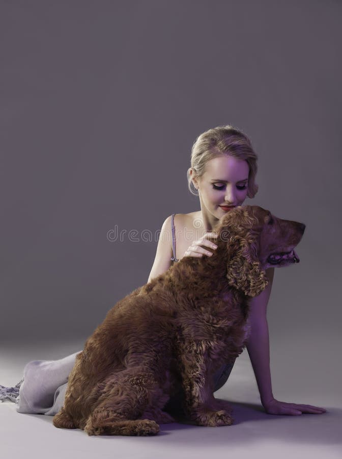 Mujer rubia hermosa que acaricia el perro del perro de aguas fotos de archivo Mujer rubia hermosa que acaricia el perro del perro de aguas fotos de archivo