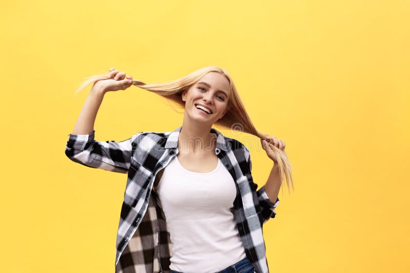 Mujer rubia joven encantadora bonita hermosa que sonríe feliz, divirtiéndose dentro, jugando con el pelo recto largo fotografía de archivo Mujer rubia joven encantadora bonita hermosa que sonríe feliz, divirtiéndose dentro, jugando con el pelo recto largo fotografía de archivo