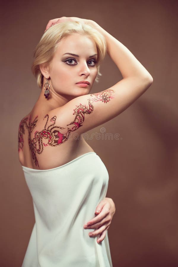 Beautiful blond woman with henna tattoo on her back. Beautiful blond woman with henna tattoo on her back.