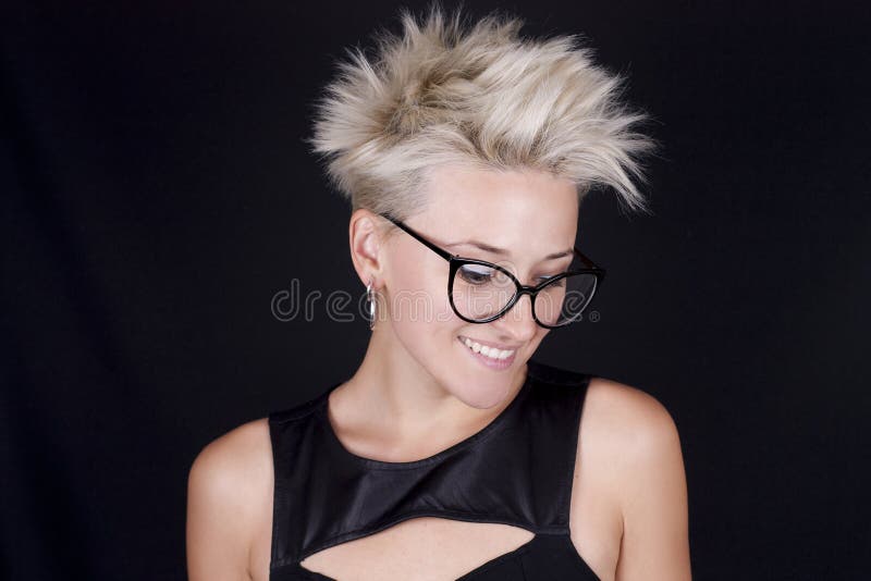 Mujer rubia joven hermosa con vidrios y un shi negro elegante foto de archivo libre de regalías Mujer rubia joven hermosa con vidrios y un shi negro elegante foto de archivo libre de regalías