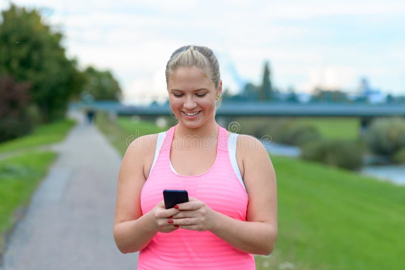 Mujer rubia joven que usa el teléfono móvil al aire libre foto de archivo libre de regalías Mujer rubia joven que usa el teléfono móvil al aire libre foto de archivo libre de regalías