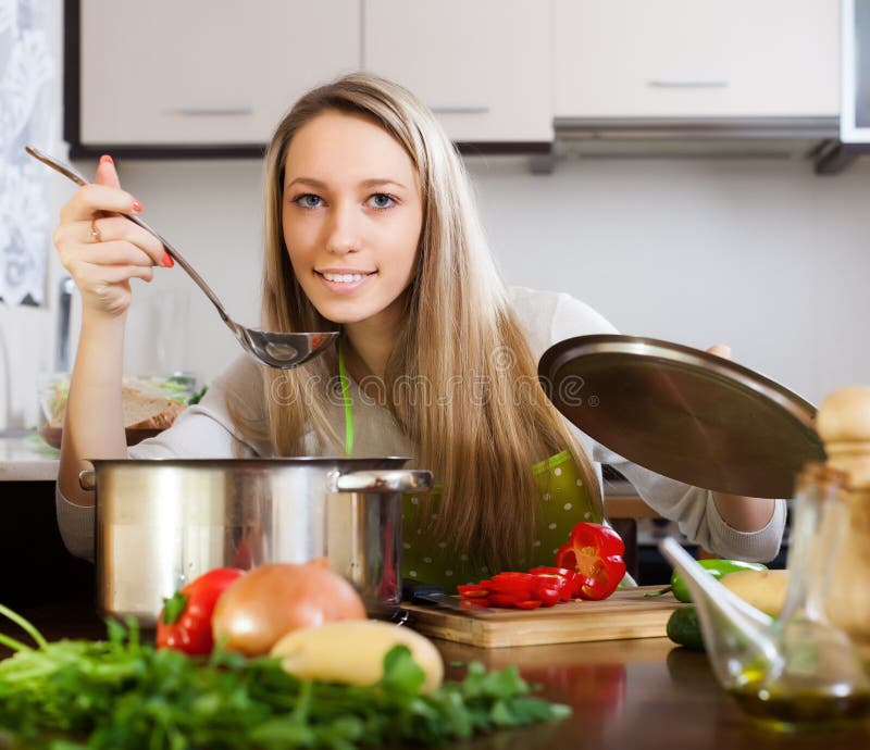 Mujer Rubia Que Cocina La Sopa Imagen de archivo - Imagen de delantal
