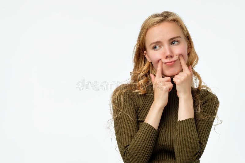 Mujer rubia rizada del trastorno joven que hace sonrisa falsa fotos de archivo Mujer rubia rizada del trastorno joven que hace sonrisa falsa fotos de archivo