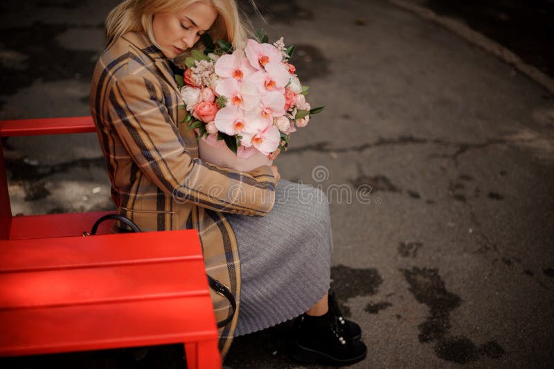 Mujer rubia romántica que se sienta en una silla roja cerca de la calle caf fotos de archivo libres de regalías Mujer rubia romántica que se sienta en una silla roja cerca de la calle caf fotos de archivo libres de regalías