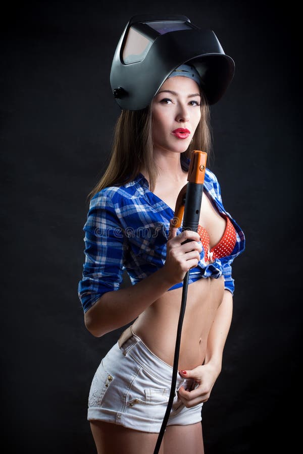 Mujer rubia sonriente hermosa en casco del soldador imágenes de archivo libres de regalías Mujer rubia sonriente hermosa en casco del soldador imágenes de archivo libres de regalías