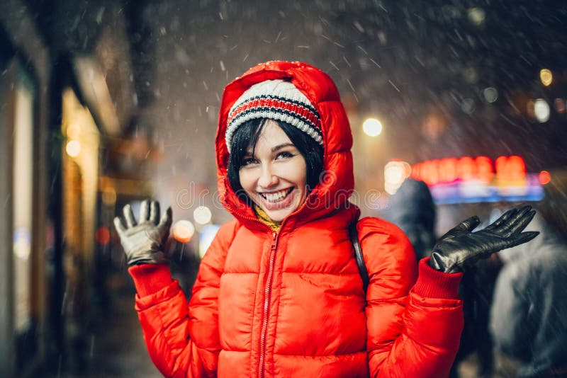 Mujer salida feliz que se divierte en la calle de la ciudad de Nueva York debajo de la nieve en el sombrero y la chaqueta que lle imágenes de archivo libres de regalías Mujer salida feliz que se divierte en la calle de la ciudad de Nueva York debajo de la nieve en el sombrero y la chaqueta que lle imágenes de archivo libres de regalías