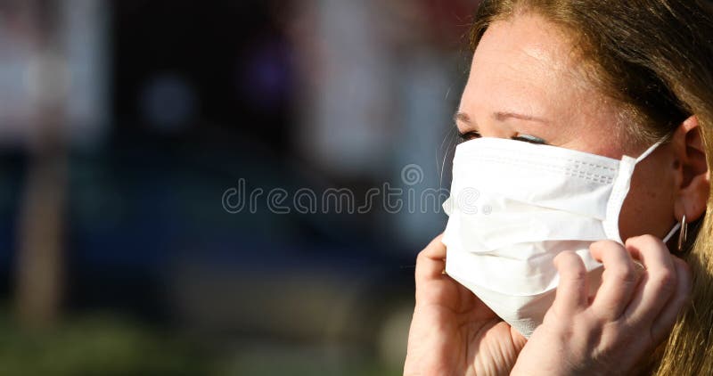 Mujer se pone una máscara para la protección contra el coronavirus covid19.