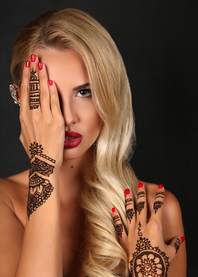 Fashion studio portrait of beautiful sensual woman with blond hair with henna tattoo on hands. Fashion studio portrait of beautiful sensual woman with blond hair with henna tattoo on hands