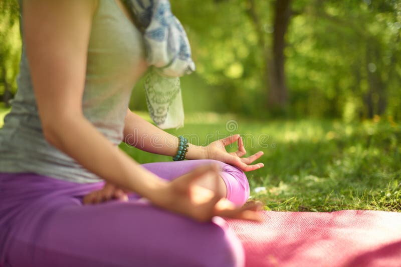 Mujer serena y pacífica que practica mindfulness atento de la conciencia meditando en naturaleza en la puesta del sol fotografía de archivo libre de regalías Mujer serena y pacífica que practica mindfulness atento de la conciencia meditando en naturaleza en la puesta del sol fotografía de archivo libre de regalías