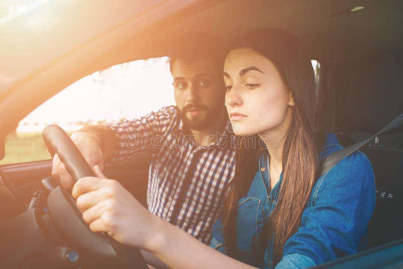 Mujer seria joven de la prueba de conducción que conduce el coche que siente inexperto, mirando nervioso el tráfico por carretera fotos de archivo libres de regalías Mujer seria joven de la prueba de conducción que conduce el coche que siente inexperto, mirando nervioso el tráfico por carretera fotos de archivo libres de regalías