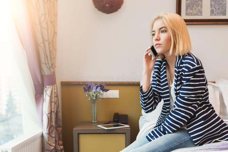 Mujer seria sentada en la habitación del hotel imagenes de archivo