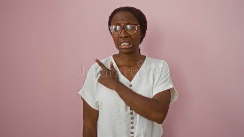 Mujer señalando su disgusto por un entorno rosa aislado imagen de archivo libre de regalías
