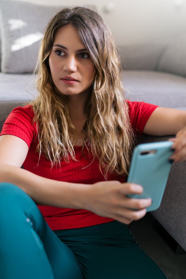 Mujer sonriendo usando un nuevo smartphone en casa imágenes de archivo libres de regalías
