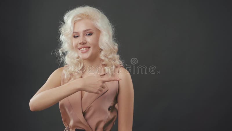 Mujer sonriente del estudiante que se?ala a la derecha. Mujer cauc?sica feliz