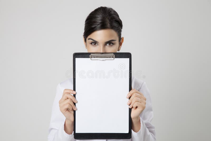 Mujer sonriente del médico con el espacio en blanco vacío en manos fotos de archivo libres de regalías Mujer sonriente del médico con el espacio en blanco vacío en manos fotos de archivo libres de regalías