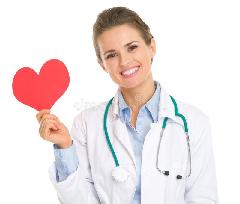 Mujer sonriente del médico que lleva a cabo el corazón de papel imagenes de archivo Mujer sonriente del médico que lleva a cabo el corazón de papel imagenes de archivo